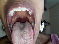 Ebony girl opens her mouth wide and pulls out long tongue